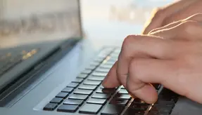 Händer som skriver på laptop