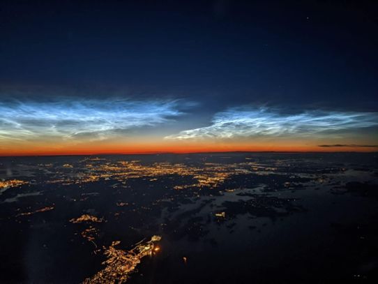 Bilden visar nattlysande moln fotograferade från ett flygplan söder om Stockholm 29 juli 2022.