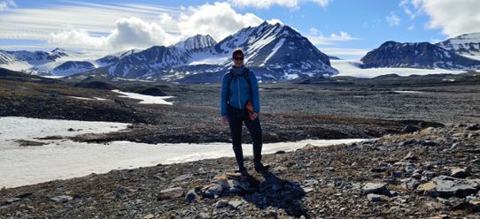 Andrea Popp on Svalbard, around her a beautiful glacial landscape.