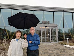 Två forskare står under ett paraply.