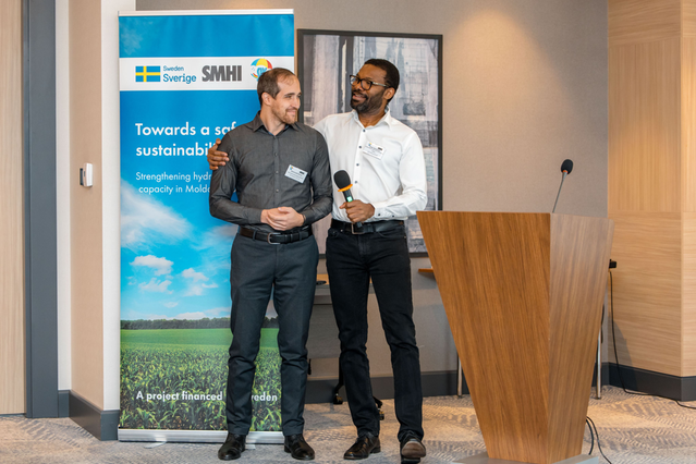 Photo of two smiling men by a lectern.