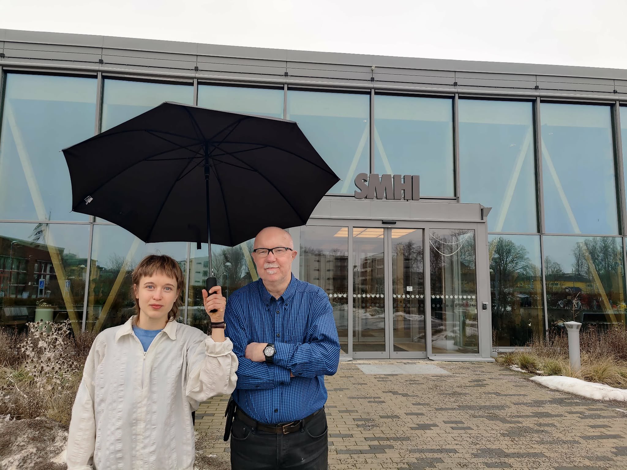 Två forskare står under ett paraply.