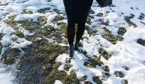 Person går genom snöslask.