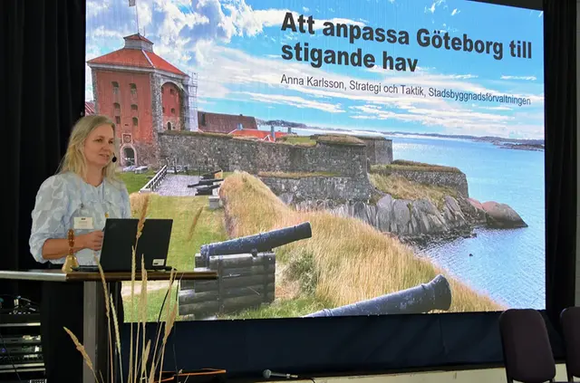 Kvinna presenterar från scen.