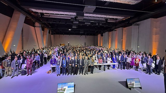 Författare för IPCC:s AR7 står tillsammans i ett stort rum och vissa av dem håller upp sina armar.