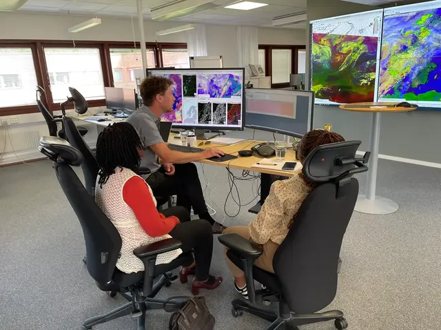 Tre personer sitter och kollar på metrologiska prognoser i SMHIs prognoscentrall.