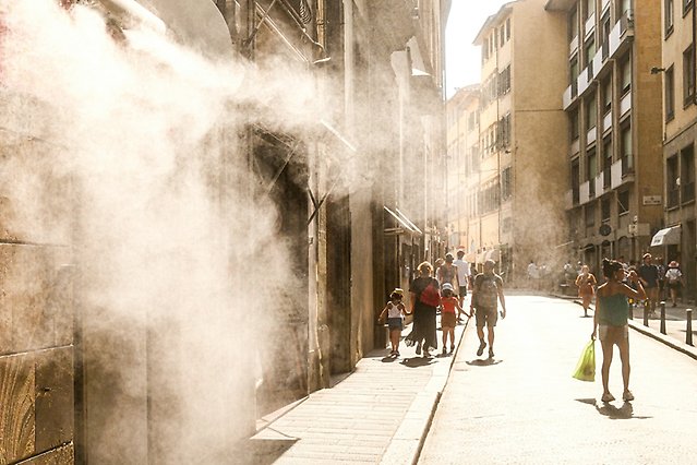 People walk around town under the warm sun.
