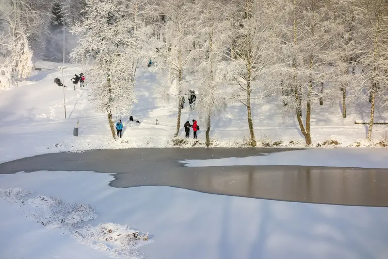 Människor vid en sjö där isen håller på att lägga sig.