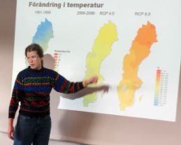 Kvinna visar temperaturförändring på karta.