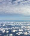 Flygfoto med moln i överkant och nederkant och blå himmel däremellan
