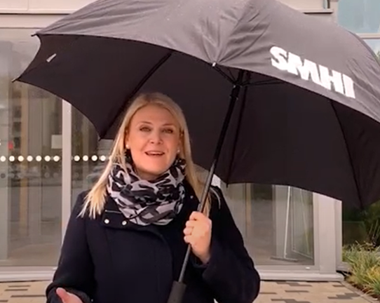Linnea Rehn under paraply utanför SMHI i Norrköping, foto.