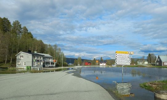 En väg har översvämmats i Ammarnäs och vägskyltarna står i vattensamlingen.