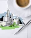 Teckning över en framtida stad. En penna och en kopp kaffe syns på bilden.