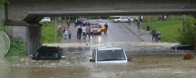 Bilden visar hur två bilar har vatten upp till bilens fönster och en bild är nästan helt under vattenytan i en underfart.
