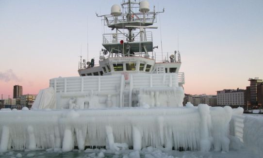 Fartyg med stora mängder is över skrov, reling och däck, foto