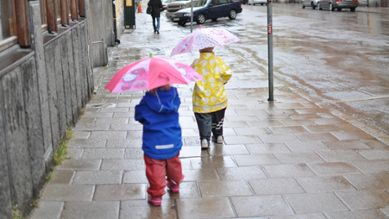 Barn med paraply i regnet, foto.